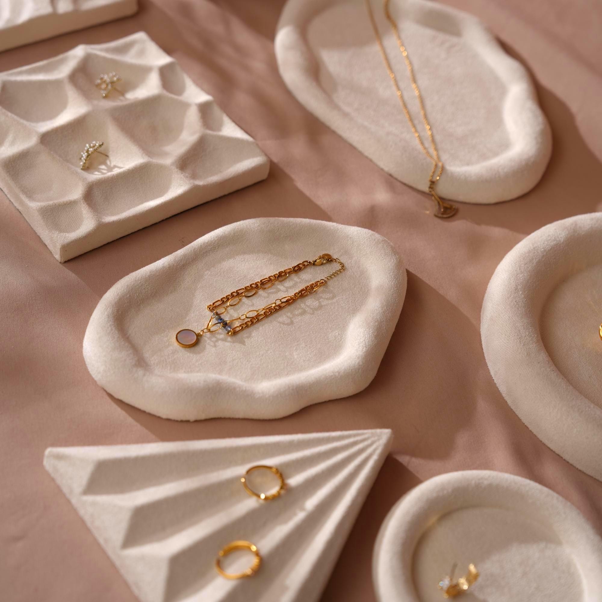 Silver hoop earrings displayed on a cream white organic suede tray against a green tatami background